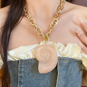 Fashionable pink acrylic snail shell pendant necklace with chunky gold chain on model