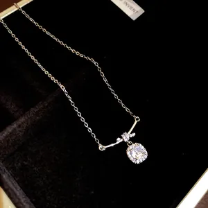 Close-up of elegant square zircon pendant on a gold-plated necklace in a jewelry box