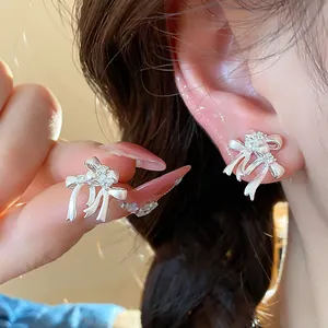 Détail macro de boucles d'oreilles nœud en argent avec incrustation de zircon