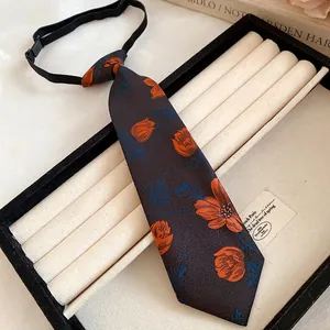 Close-up of a vintage handmade floral embroidered tie necklace in a jewelry box.