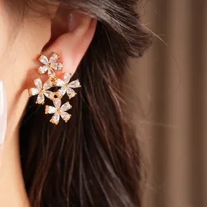 Macro detail shot of elegant gold-plated zircon flower cluster earrings for women