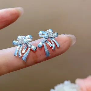 Gros plan exquis de boucles d'oreilles nœud argentées ornées de zircons étincelants