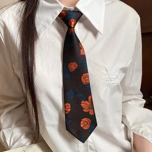 Detailed macro view of vintage handmade floral embroidered tie necklace on a white shirt