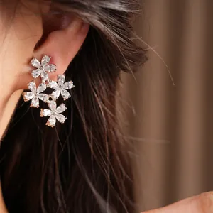 Close-up of elegant zircon flower ear clips worn on ear for non-pierced lady ears