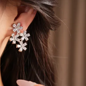 Close-up of elegant flower ear clips with sparkling zircons and gold plating