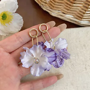 Detailed view of large purple gradient fabric flower earrings with golden hoop accents