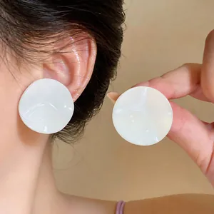 Close-up view of white pleated round stud earrings in a minimalist Korean sweet style.