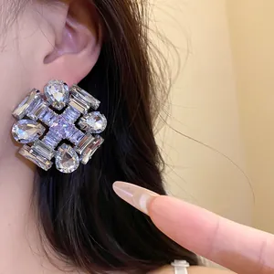 Close-up of large geometric zircon stud earrings with sparkling crystals