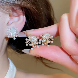 Close-up of elegant firework-shaped earrings with pearls and brilliant cubic zircons