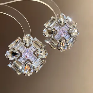 Macro view of luxurious geometric silver needle earrings with shimmering zircons