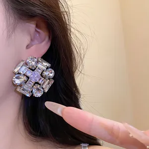 Close-up detail of sparkling zircon cluster floral stud earrings worn on a female model ear