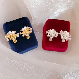 Detailed macro view of elegant firework ear clips with pearls and zircons on velvet displays