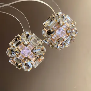 Detailed macro view of sparkling zircon rhombus stud earrings with elegant silver needles