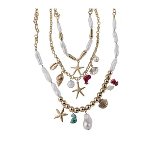 Multilayered ocean-themed gold necklace with pearls, starfish, and shell charms.