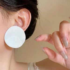 Detailed close-up showing white pleated round stud earrings in a sweet Korean style