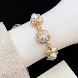 Elegant vintage court style bracelet featuring pearls and gold-textured luxury finish