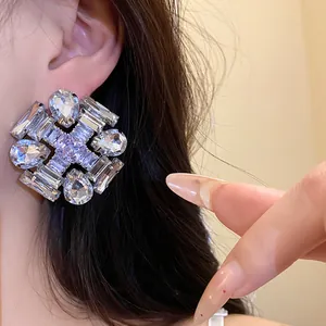 Close-up detail of luxury geometric zircon stud earring with a silver needle post.