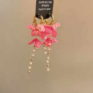 Vue détaillée de boucles d'oreilles fleurs en résine rose et perles chic