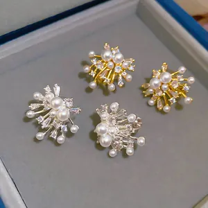 Detailed macro view of fireworks-inspired pearl and zircon ear clips in gold and silver
