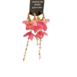 Boucles d'oreilles créoles fleurs en résine rose avec pompons de perles et finitions dorées