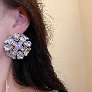 Close-up detail view of luxury cubic zirconia geometric stud earrings worn on the ear