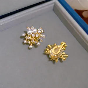 Macro detail of gold plated pearl and zircon fireworks design clip-on earrings for women.