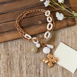Vintage gold flower pendant necklace with mixed metal chain and white acrylic links