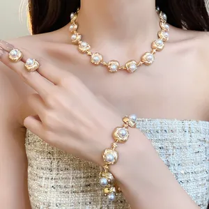 Detail view of vintage style gold necklace, bracelet and earrings set with pearls