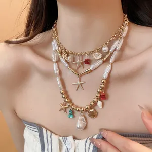 Detail view of a multilayered beach-style necklace with golden starfish and shell charms.