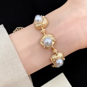 Elegant vintage gold-tone linked bracelet featuring textured square motifs and large pearls