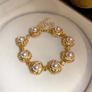 Detailed view of vintage gold-tone pearl bracelet with elegant textured links
