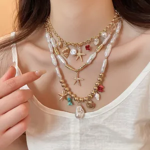 Bohemian layered necklace featuring golden starfish, shells, and elegant white pearls detail