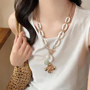 Detail of vintage flower pendant necklace with chunky links on a female model