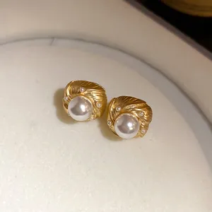Vintage court style gold stud earrings featuring textured swirl design and elegant pearls
