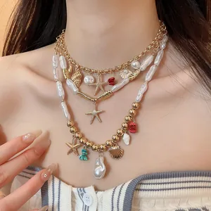 Detailed view of layered boho necklace with starfish, shell charms and baroque pearls.