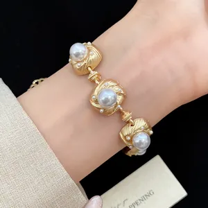 Close-up detail of a luxury vintage gold bracelet featuring elegant large pearls on a wrist