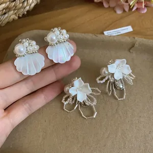 Elegant pearl shell and flower stud earrings for a charming French vacation look.