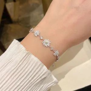 Elegante pulsera de margarita de plata con circonitas brillantes en la muñeca de mujer