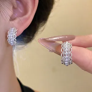 Elegantes pendientes de aro en forma de C con perlas sintéticas y pedrería brillante.