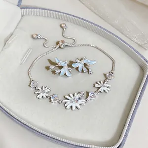 Elegante conjunto de joyas plateadas con margaritas, circonitas y detalles azules