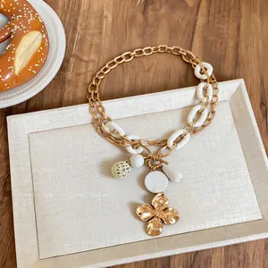 Detailed view of a retro floral and water drop pendant necklace with gold-toned TO chain