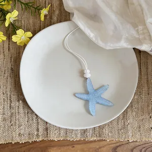 Vista dettagliata di una collana con ciondolo a stella marina blu su un piatto bianco