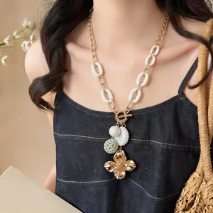 Detailed view of a vintage flower pendant necklace with a toggle clasp on a model.