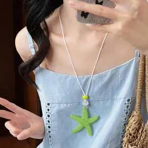 Dettaglio di una collana con ciondolo a stella marina in resina verde lime