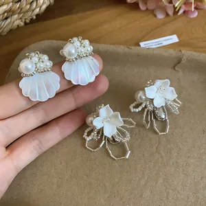Close-up of French classic pearl shell and flower earrings with intricate beadwork