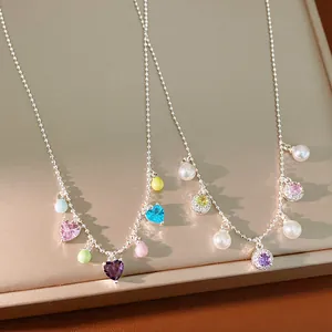 Detailed view of colorful heart and round zircon stones with pearls on silver chains.