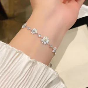 Primer plano de una elegante pulsera de margaritas de plata con circonitas en la muñeca