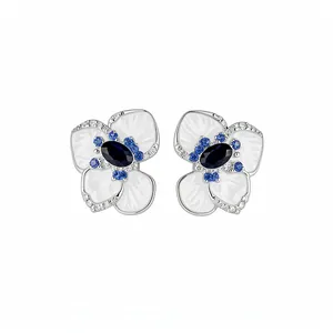 Eleganti orecchini a lobo a fiore in argento con pietre blu e petali in smalto bianco.