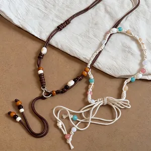 Bohemian braided waist chain with colorful wood beads and shells on neutral background.