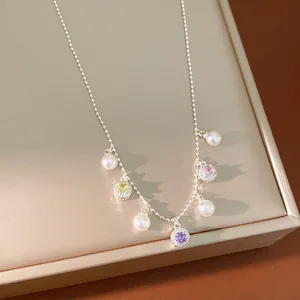 Exquisite close-up of dainty silver necklace with colorful zircons and pearls on display